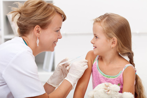 Barn som får en injektion i armen av vårdpersonal.