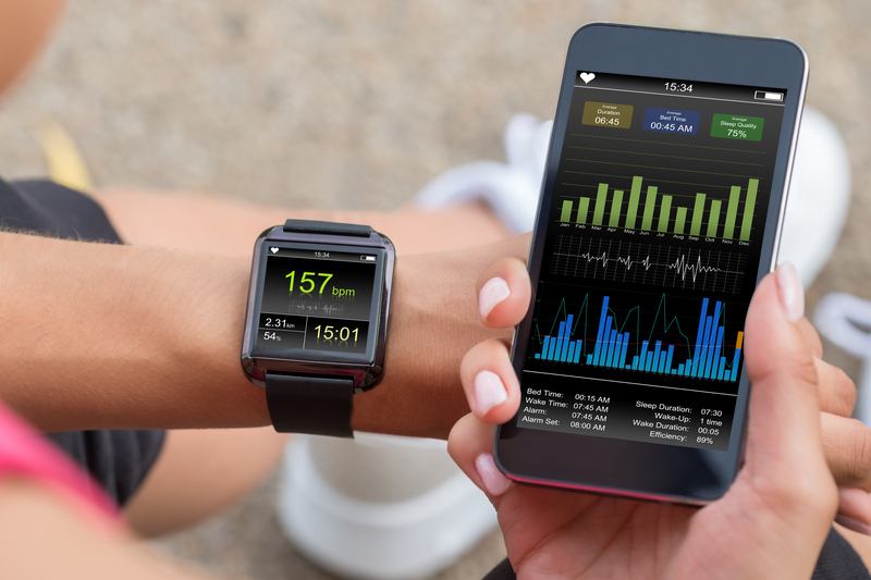 En löpare betraktar sin puls och andra träningsvärden på sin telefon och smartklocka.