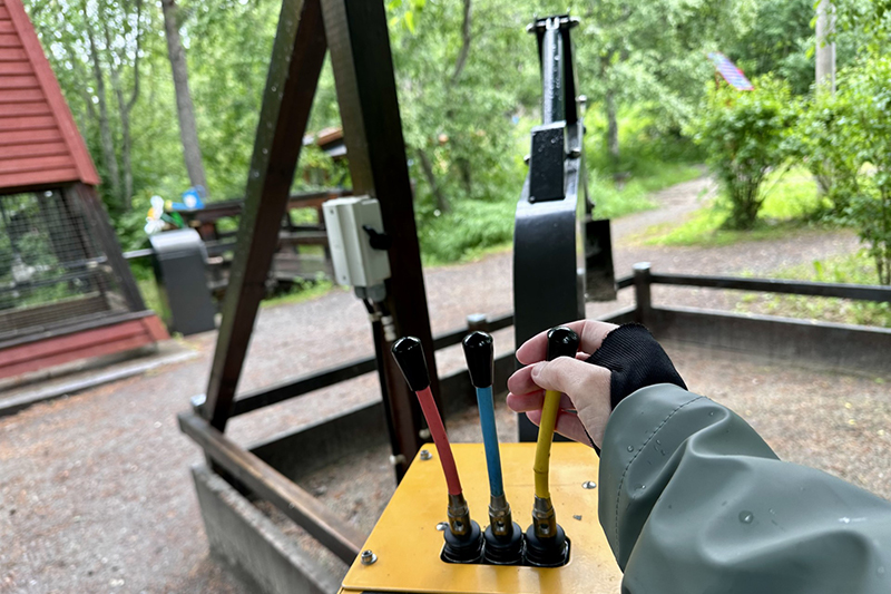 Närbild på högerhand som sköter spakarna på grävmaskin