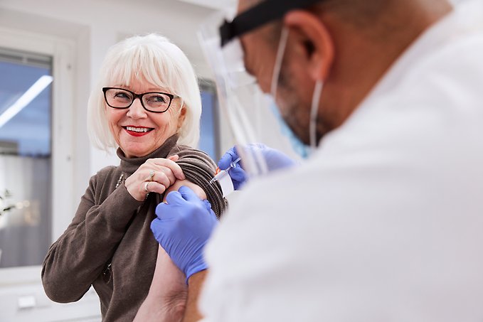 Läkare ger vaccin till en äldre patient.