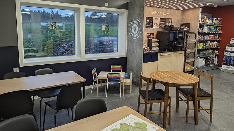 Nyrenoverad kaffehörna med sittgrupper, bord och stolar. På ena bordet ligger en turismkarta över Jämtland.