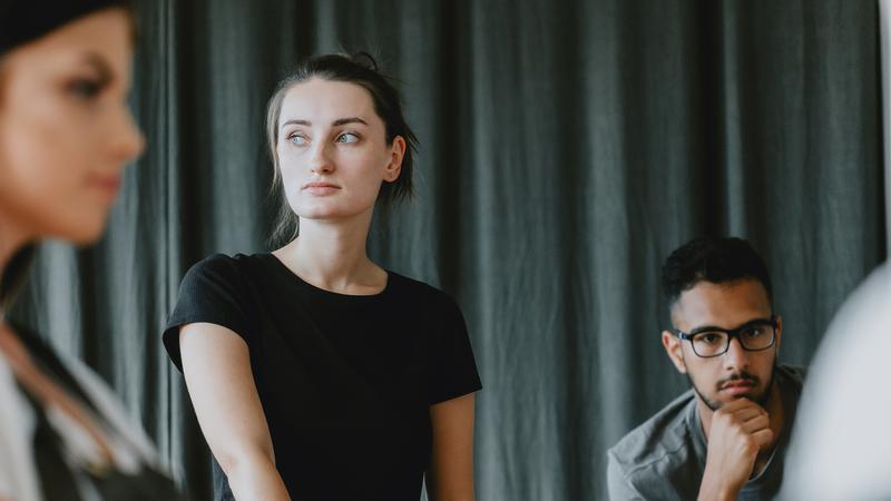 Unga allvarliga personer varav en person i fokus och övriga suddiga.