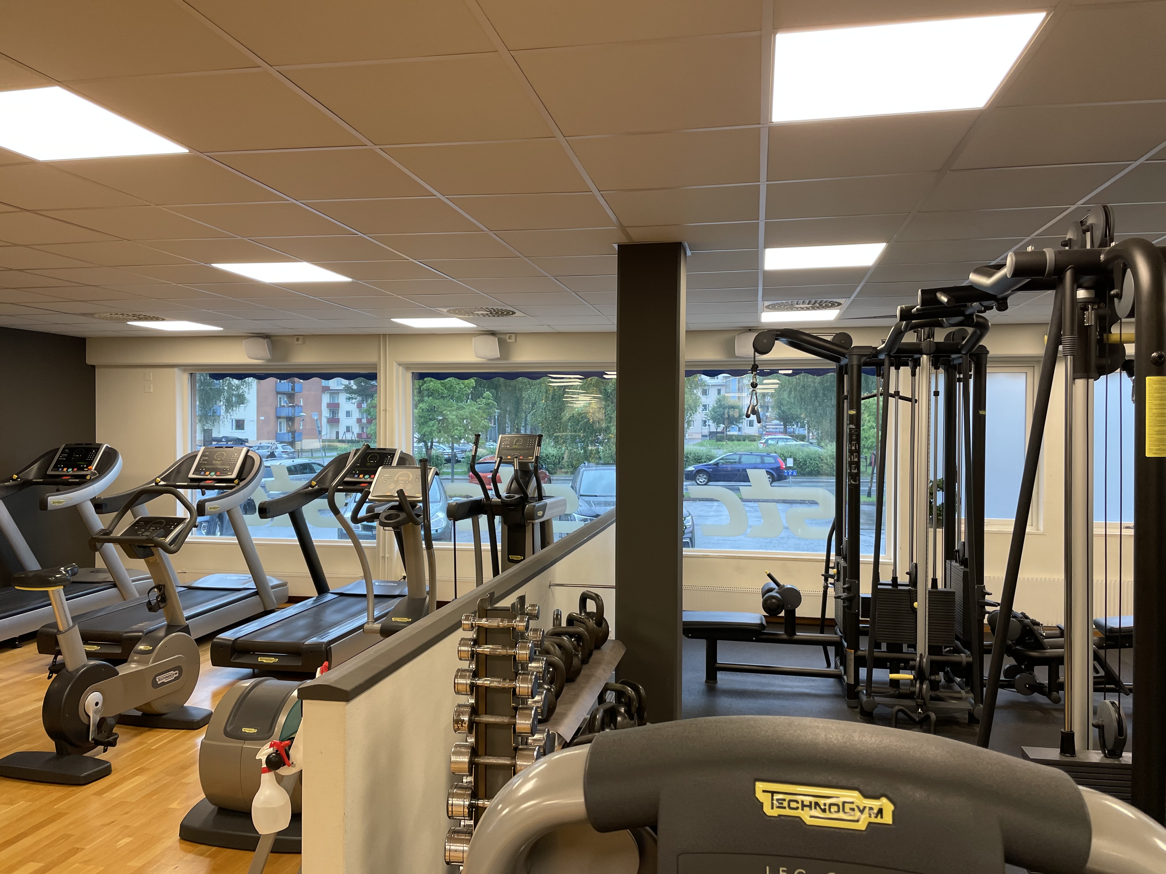 Gymdel med hantlar, kettlebell, gång- och löpband, cyklar samt ställning som det går att utföra övningar i sittande eller stående.