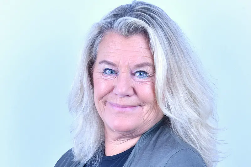 Närbild på leende person med blont hår och blå ögon