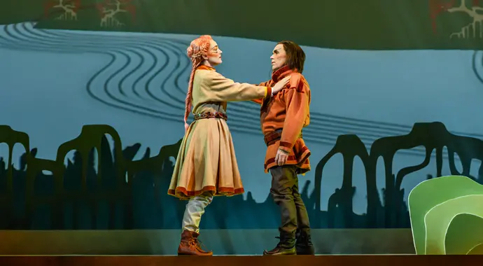 Två personer står mitt emot varandra på en scen. 