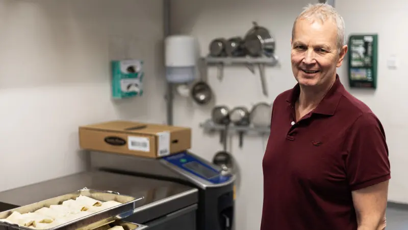 Porträttbild av en man i köksmiljö.