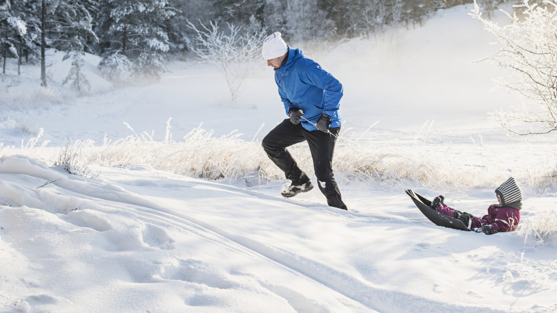 Två skolungdomar pratar och ler sittandes på en buss.