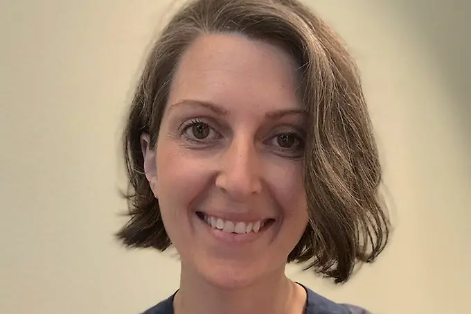 Ett leende ansikte tittar in i kameran. 