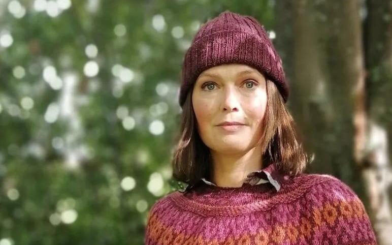 Porträtt på företagaren Susanne Österberg i handstickad mössa och tröja från egna företaget Beknitted.