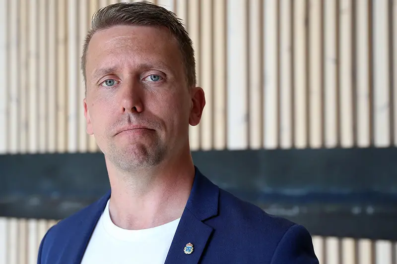 Foto på person i kortklippt frisyr och kornblå kavaj