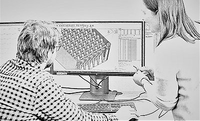 Två personer arbetar vid en datorskärm med en tre dimensionell modell.