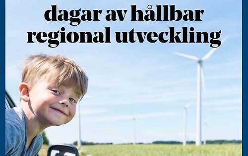 En glad pojke med vindkraftspark i bakgrunden