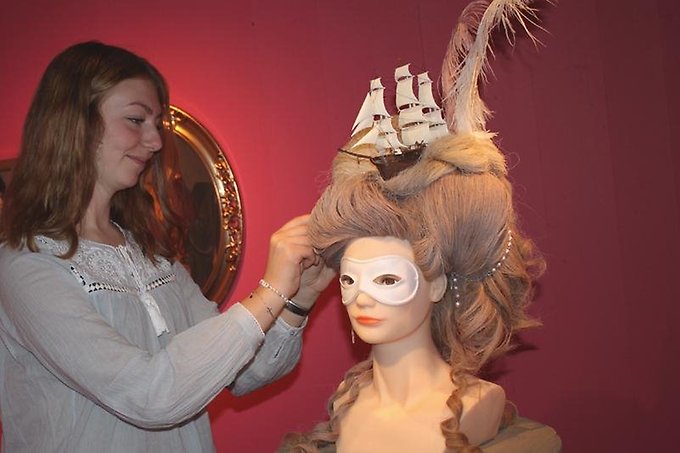 En kvinna fixar med ett frisyrhuvud