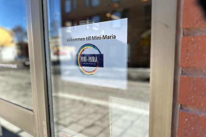 Foto på en glasad entre´dörr med texten Välkommen till Mini-Maria