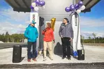 Tre personer står bland ballonger vid invigningen av en laddningsstation för lastbilar.