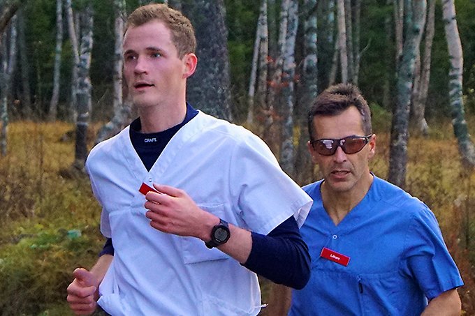 Två läkare i sjukhuskläder i ett löparspår