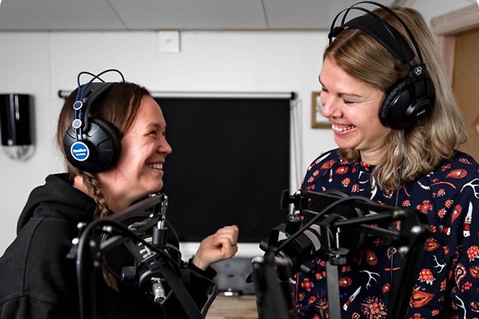 Två personer ler mot varandra i en ljudstudio