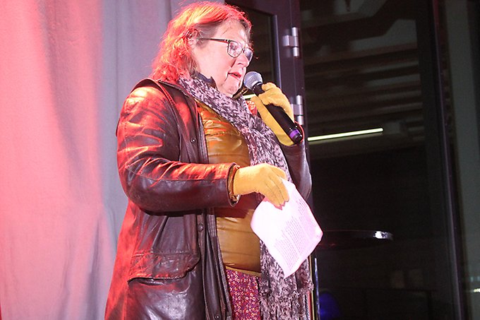 En person står på en utomhusscen och håller ett tal