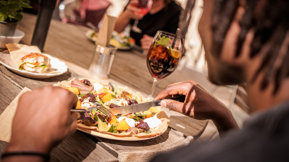 Två personer äter mat på en restaurang. 