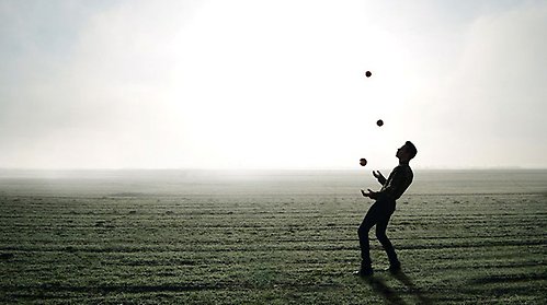 En person sitter med förstoringsglas över ett par färgade staplar med figurer på.