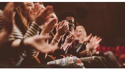 Sittande personer som klappar händerna.