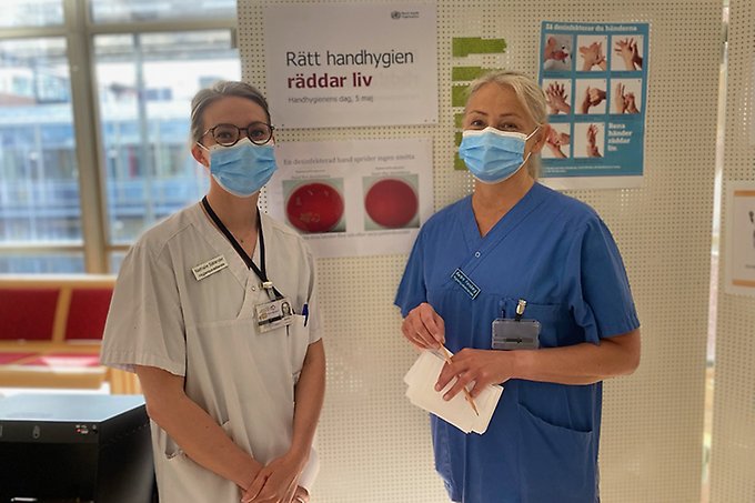 Två sjukvårdspersonal står med munskydd på sig