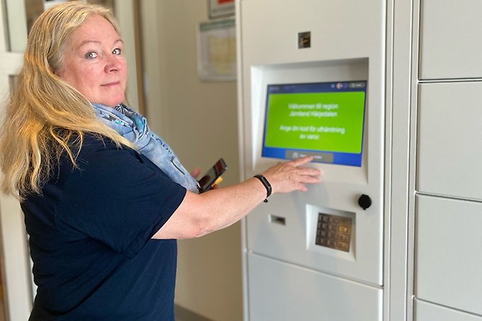 En person står framför en dataterminal och tittar in i kameran från sidan