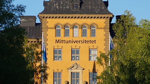 En byggnad med gul fasad. På byggnaden står det Mittuniversitetet.