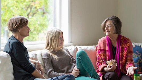 Trepersoner sitter och pratar i en soffa.